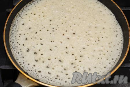 Сковороду (я взяла сковородку диаметром 20 сантиметров) хорошо разогреть, немного смазать растительным маслом, влить небольшой половник теста, сразу распределить его по дну сковороды. Жарить блин на среднем огне. Благодаря тому что тесто на кефире и кипятке замешивается с добавлением соды, поверхность блинчика станет ажурной, покроется мелкими дырочками.