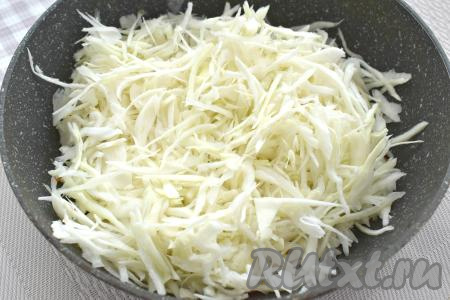 Моем капусту, убираем с поверхности подпорченные листья. 400 грамм подготовленной капусты нарезаем на тонкие полоски и добавляем в сковороду с обжаренными овощами, перемешиваем. Обжариваем на огне выше среднего 5 минут. За это время капуста немного обмякнет.