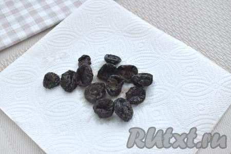 Пока тушится капуста, чернослив промываем водой, кладём в миску, заливаем кипящей водой, оставляем на 5 минут. Затем воду сливаем, а чернослив обсушиваем, разложив его на бумажных полотенцах.