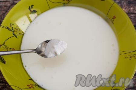 В глубокую тарелку (или миску) влить кефир, сразу же добавить соду, тщательно перемешать ложкой.