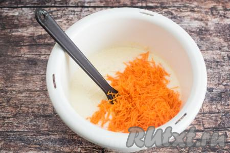 К взбитым яйцам, смешанным с кефиром и маслом, добавить натёртую морковку, аккуратно перемешать лопаткой, равномерно распределяя овощи по яично-кефирной смеси.