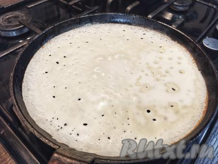 Сковороду хорошо разогреваем, смазываем растительным маслом. "Отдохнувшее" тесто ещё раз перемешиваем. Наливаем половник теста на разогретую сковороду. Сразу распределяем тесто по дну сковороды. Выпекаем блин на среднем огне до подрумянивания снизу.