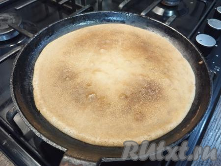 Переворачиваем лопаткой блин на другую сторону. Выпекаем до румяности с другой стороны.