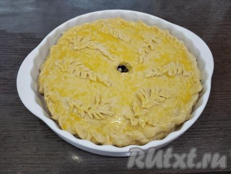 Затем в небольшой ёмкости взбиваем вилкой яичный желток до однородности, смазываем им верх пирога. Благодаря смазыванию желтком верх готового пирога будет более румяного цвета.