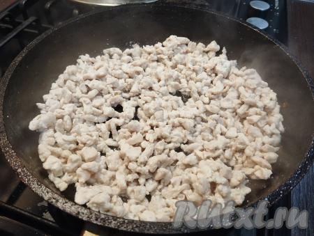 На сковороду, в которой обжаривались грибы с луком, добавляем немного растительного масла, выкладываем нарезанное куриное мясо, обжариваем его, иногда перемешивая, в течение 10-12 минут (до готовности филе) на среднем огне.