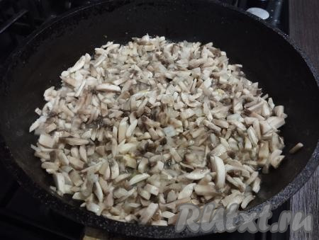 Шампиньоны и лук нарезаем мелко. На сковороде хорошо прогреваем растительное масло, выкладываем грибы с луком и жарим на среднем огне минут 7-8 (до готовности грибов и мягкости лука), периодически перемешивая. Жареные шампиньоны с луком перекладываем со сковороды на тарелку.
