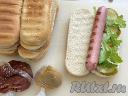 На огурчик выложить листья салата, а сверху - горячую сосиску.