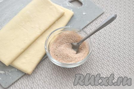 В небольшой миске смешиваем сахар с молотой корицей. Я добавила 2 столовых ложки сахара, поэтому готовое слоёное печенье "Ушки" получилось сладким.