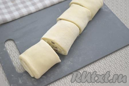 Получившийся рулет из слоёного теста с творожной начинкой разрезаем острым ножом на 4 равных части.
