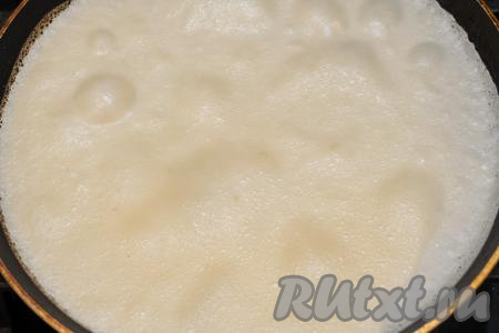 Сковороду хорошо разогреть, перед выпечкой первого блина немного смазать её растительным маслом. Влить небольшой половник блинного теста на раскалившуюся сковороду, сразу наклонить сковородку из стороны в сторону, чтобы тесто равномерно распределилось по дну сковороды. Огонь уменьшить до среднего. Жарить блин до подрумянивания снизу. Для того чтобы даже первый блин не вышел комом, переворачивать нужно только тогда, когда тонкий блинчик хорошо подрумянится с нижней стороны. Для того чтобы перевернуть тонкий блинчик, я поддеваю край блина лопаткой, берусь сухой рукой за краешек блина и приподнимаю его. Затем просовываю лопатку и переворачиваю блин на другую сторону. Обязательно руки должны быть сухими, так как они меньше проводят тепло. Мокрыми руками поддевать блин нельзя, будет горячо.