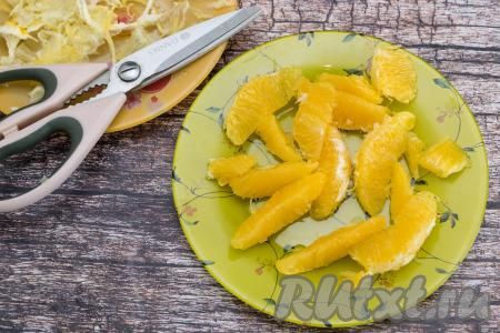 Апельсин вымыть, очистить от кожуры, разделить на дольки. Очистить дольки апельсина от плёночек. Я очищаю дольки от плёночек с помощью кухонных ножниц. Для этого ножницами я отрезаю плёночку с верха каждой дольки, а затем просто снимаю плёнку с двух сторон каждой дольки. Благодаря ножницам, очищается апельсин от плёночек очень быстро и просто.