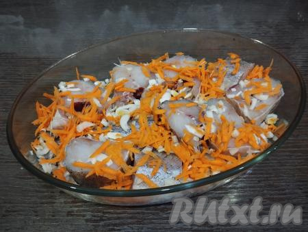 Выкладываем кусочки минтая в один слой в форму для запекания. Поверх рыбы равномерно раскладываем обжаренные морковку и лук.&nbsp;