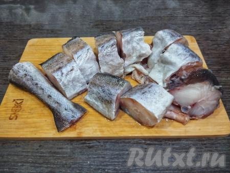 Удаляем у минтая внутренности вместе с чёрной плёночкой из брюшка, отрезаем плавники рыбы. Промываем минтая водой. Нарезаем рыбу на порционные кусочки (ориентировочно толщиной 2-3 сантиметра). Кусочки минтая солим и приправляем специями для рыбы со всех сторон.