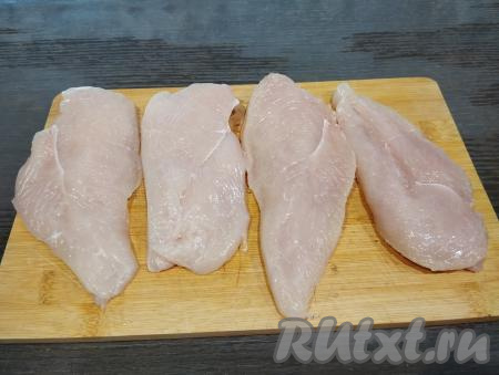 Каждое филе разрезаем вдоль на две части. В результате из 2 куриных филе у нас получатся 4 куска мяса, именно столько отбивных мы и будем готовить. Выкладываем 4 куска мяса на разделочную доску.