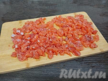 Пока ракушки из слоёного теста остывают, приготовим начинку. Для этого красную рыбу нарезаем на мелкие кубики (со стороной ориентировочно 5 миллиметров).