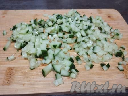 Огурец нарезаем на такие же мелкие кубики, как была нарезана рыба.