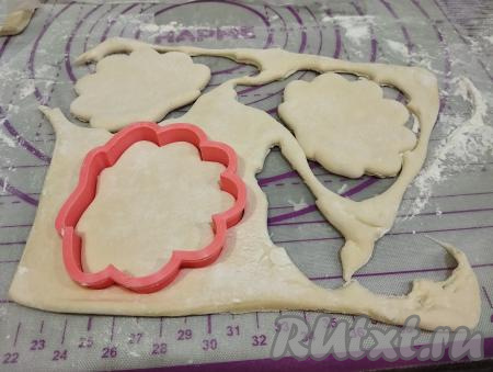Раскатываем тесто скалкой, но не тонко, примерно до толщины 4-5 миллиметров. Формочкой для печенья вырезаем ракушки. У меня из одного пласта получились 4 ракушки. Обрезки теста соединяем, опять раскатываем и ещё вырезаем ракушки. Всего из двух пластов слоёного теста я вырезала 12 ракушек. Я вырезала формочкой размером 8 на 9 сантиметров. Если у вас нет формочек, тогда можно вырезать заготовки ракушек обычной кружкой.