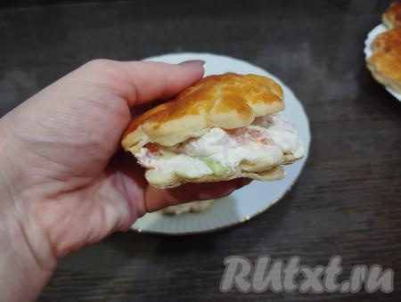 Каждую остывшую ракушку разрезаем ножом, но не до конца. Столовой ложкой выкладываем в середину каждой ракушки начинку из творожного сыра, красной рыбы и огурца.