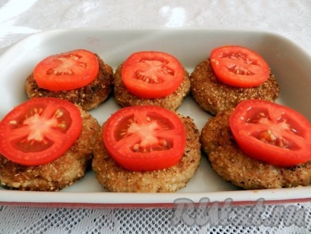 Помидоры нарезать на кружочки и выложить сверху на котлеты. Поставить форму в разогретую до 190 градусов духовку и запекать котлеты с помидорами 20-25 минут.