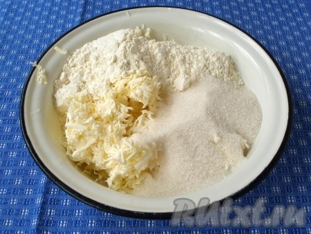 Замороженное масло натереть на тёрке, смешать с сахаром, мукой и разрыхлителем в крошку.