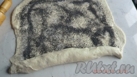 Растереть дрожжи, добавить подогретую воду, растительное масло и сахар. Перемешать, пока сахар и дрожжи полностью не растворятся. Добавить муку и замесить тесто для рулетиков. Тесто должно оставаться достаточно мягким, но при этом должно отставать от стенок ёмкости, в которой замешивалось. Оставить тесто на один час в теплом месте для подхода. Готовое тесто раскатать в прямоугольный лист толщиной приблизительно 5 -7 мм. Посыпать лист сахаром, затем маком. Свернуть лист вдоль в тугой рулет.
