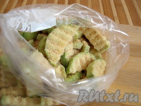 Положить в пакет с сухарями все брусочки кабачка. Хорошенько встряхнуть пакет, чтобы все кусочки покрылись сухарями с чесноком.

