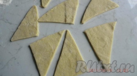 Раскатать их, постоянно припудривая "сахарной мукой". Разрезать тесто на треугольники.
