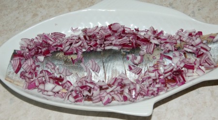 Нарезанный лук выложить на селедку.