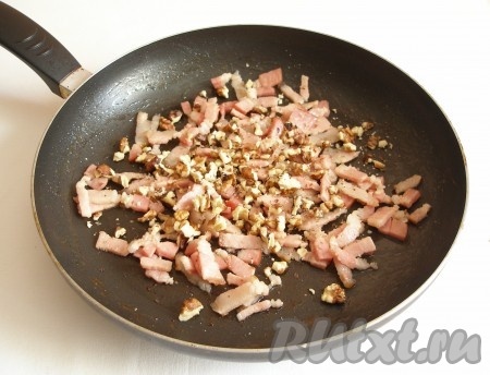 В сковороде обжарить бекон на среднем огне в течение 2-3 минут, затем добавить порубленные орехи, обжарить 3-4 минуты, помешивая (если орехи добавлять не будете, то просто обжарьте бекон в общей сложности в течение 5-7 минут).
