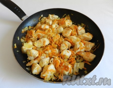 Обжарить куриное мясо на растительном масле на среднем огне до изменения цвета со всех сторон, затем добавить нарезанный лук и натёртую морковь. Обжаривать овощи с куриным мясом минут 5, не забывая помешивать.
