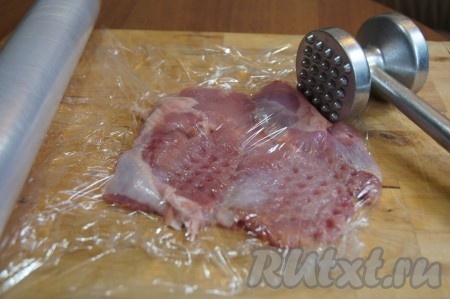 На пищевую пленку положите бедрышко, сверху тоже разместите пищевую пленку и отбейте (отбивайте очень тонко, иначе завернуть начинку не получится).