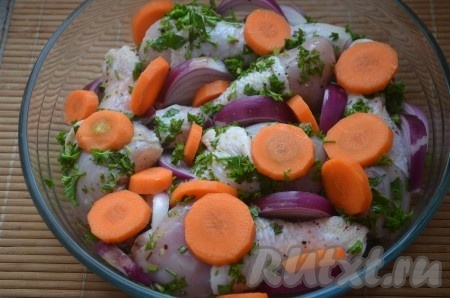 Очищенную луковицу нарезать крупными дольками, очищенную морковку - кружочками. Выложить замаринованные куриные голени в смазанную маслом форму, сверху и между кусочками курочки разложить нарезанные лук и морковь.
