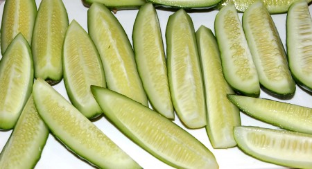 Если огурцы переросшие, то разрезать их на четвертинки. Маленькие огурчики использовать целиком.