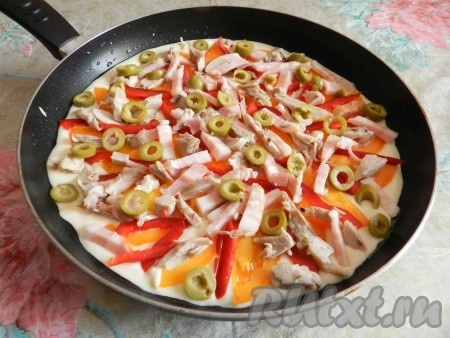 Холодную сковороду смазать маслом. Вылить тесто, разложить начинку и посыпать тертым сыром. Поставить сковороду на средний огонь, накрыть крышкой и готовить пиццу 15-20 минут до готовности теста.