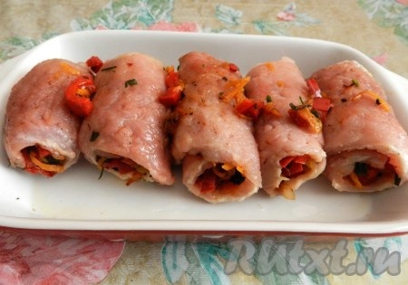 Форму для запекания слега смазать растительным маслом. Каждый кусок свинины, покрытый овощами, свернуть в рулетик. Выложить сформированные рулетики из свинины с овощной начинкой в форму для запекания. Если остались жареные овощи, их можно выложить поверх рулетов или рядом с ними. Накрыть форму для запекания фольгой и поставить в разогретую до 200 градусов духовку на 30 минут. Затем фольгу снять и запекать рулетики из свинины ещё 15-20 минут.