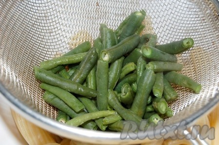 Зеленую стручковую фасоль порезать, опустить  в кипящую воду, проварить 5 минут на маленьком огоньке и выключить огонь. Переложить в сито, чтобы стекла лишняя жидкость и фасоль остыла.