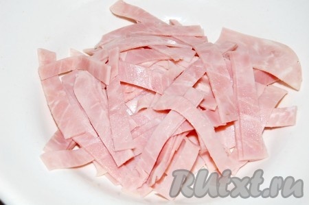 Нарезать ветчину некрупной соломкой.