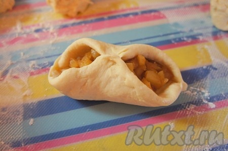 Защипываем сначала центр, затем бока (как показано на фото), а затем защипываем весь край пирожка. Таким образом, пирожки с яблоками получатся аккуратные и не раскроются при выпечке.