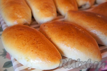 Готовые горячие пирожки смазываем сливочным маслом, накрываем полотенцем и даём им немного остыть.