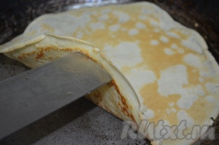 Раскалённую сковороду смазать маслом, вылить половник теста и, равномерно распределив его по поверхности сковородки, жарить блинчик на среднем огне с двух сторон до золотистости, затем переложить на тарелку. Аналогично пожарить все блины из оставшегося теста. В принципе, если сковорода хорошего качества, то смазывать её нужно только перед жаркой первого блина, так как растительное масло входит в состав блинного теста.