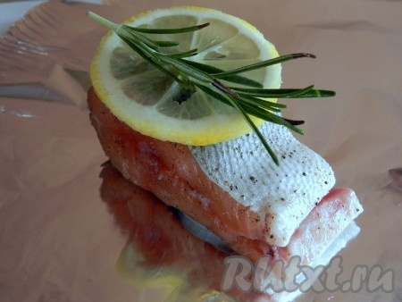 На фольгу выложить кольца лука, сверху кусочек семги, накрыть колечком лимона, положить веточку розмарина. Поднять концы фольги и плотно свернуть.