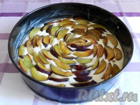 По поверхности теста выложить сливы.