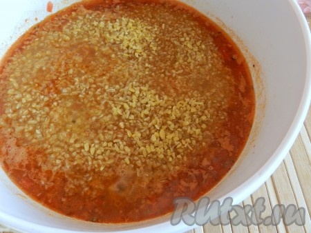 В кастрюлю с мясом и овощами добавить помидор с чесноком и специями, перемешать, посолить по вкусу. Всыпать булгур и долить воды. Количество воды должно быть в 1,5-2 раза больше количества булгура.