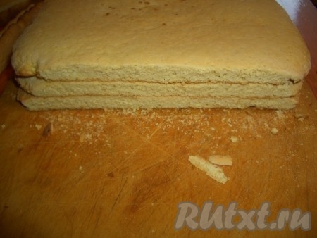 Готовые коржи сложить друг на друга и обрезать края, придав им форму прямоугольника. Обрезки перетереть в крошку.