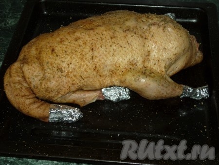 Концы крыльев и ног завернуть в фольгу. Выложить утку, фаршированную яблоками, на противень (или в форму для запекания) и отправить в духовку, разогретую до 180 градусов, на 40-50 минут. В процессе запекания достаточно часто поливаем утку выделяющимся жиром.