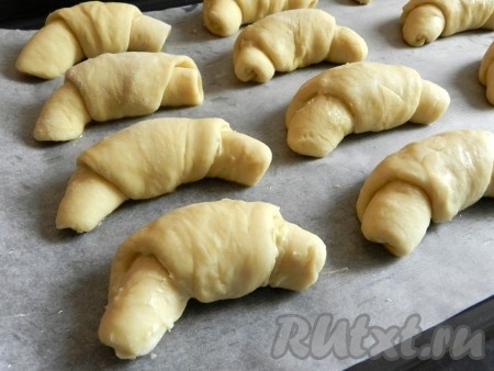 Противень застелить бумагой для выпечки, смазать маслом и выложить рогалики на расстоянии друг от друга.
