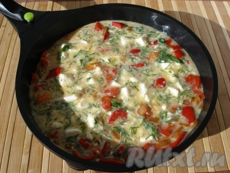 Яичную смесь вылить в сковороду к овощам, уменьшить огонь, накрыть крышкой и готовить 10 минут.