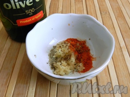 Смешать специи, соль, чёрный молотый перец,  2-3 столовых ложки оливкового (или подсолнечного) масла и пропущенный через пресс чеснок.