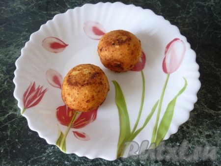 Как только пончики всплывут и зарумянятся, вынуть их шумовкой, вначале поместить на бумажные полотенца (или салфетки), чтобы убрать лишнее масло, а затем переложить на тарелку. Аналогично влажными руками сформировать следующую партию круглых творожных пончиков и тоже пожарить их во фритюре.