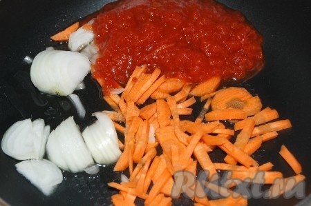 Нарезать очищенные морковь с репчатым луком некрупной соломкой, добавить томатную пасту и обжарить на растительном масле на среднем огне, помешивая время от времени, до полуготовности (на это потребуется 5-7 минут).
